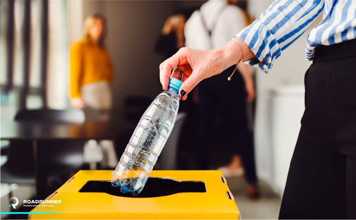 an office work disposes of their paste recycling in a recycling bin