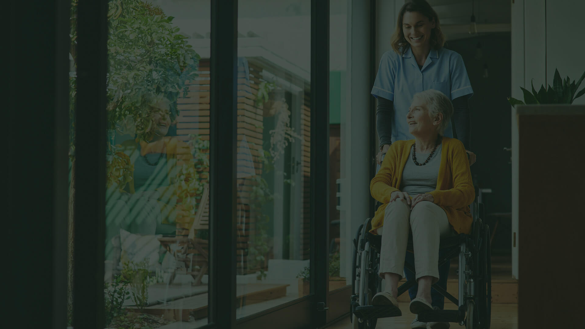 A nurse assisting an elderly woman in a wheel chair at a healthcare facility