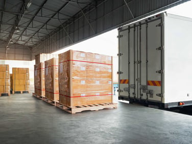 A warehouse dock with pallets of boxes ready to be loaded into a truck