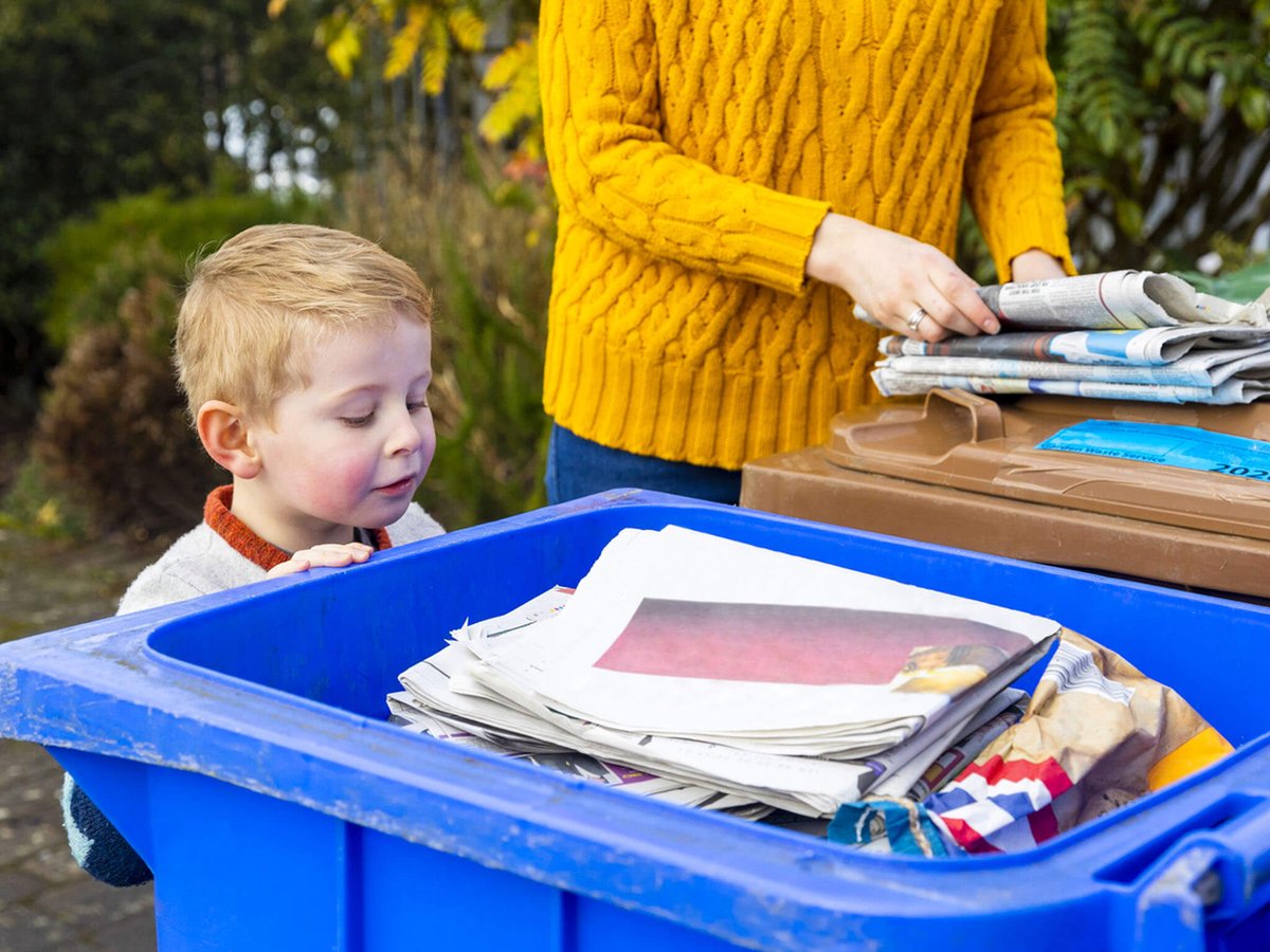 a student a teacher recycle old newspapers